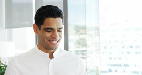Happy Businessman Using Tablet in Modern Office Environment