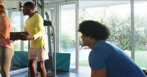 Friends Engaging with Fitness Technology During Home Gym Workout