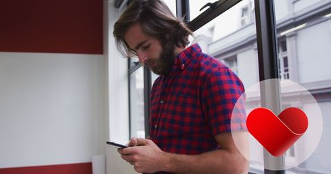 Caucasian Man Looking at Smartphone in Office with Red Heart Icon - Download Free Stock Images Pikwizard.com