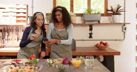 Diverse Friends Sharing Smartphone Moments While Cooking Together