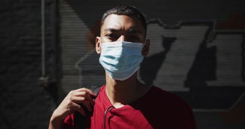 Young Biracial Man Wearing Protective Face Mask for Safety in Urban Area