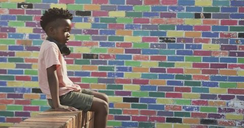 Urban Youth Enjoying Music by Colorful Brick Wall Mural