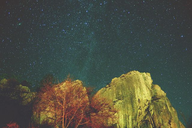 Breathtaking view of a starlit night sky over majestic rocky cliffs. Ideal for use in nature-themed publications, travel blogs, geology studies, and outdoor adventure marketing. Perfect background image for astronomy and night sky enthusiasts.