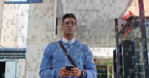 Young professional holding smartphone outside office with binary data overlay