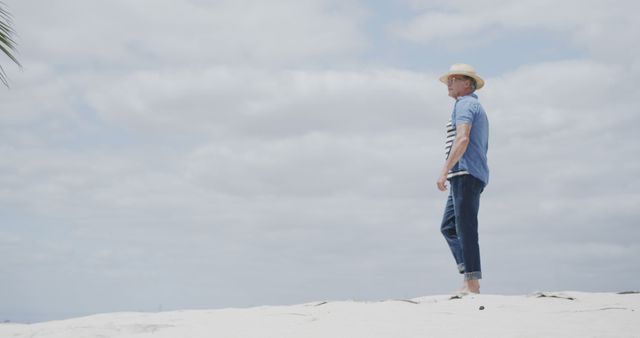 Man Relaxing on Sandy Beach Under Partly Cloudy Sky - Download Free Stock Images Pikwizard.com