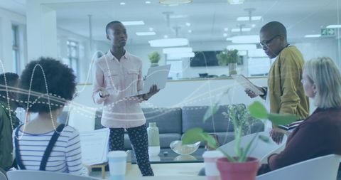 Diverse team in office analyzing data with digital interface