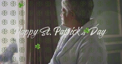 Senior woman gazing by window in robe with st patrick's day clover overlay, serene portrait