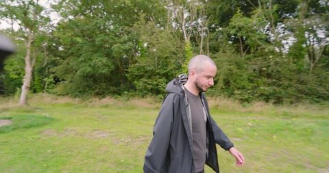 Man walking peacefully in green park scene