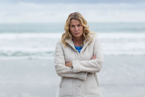 Woman in Winter Coat Standing on Cold Beach