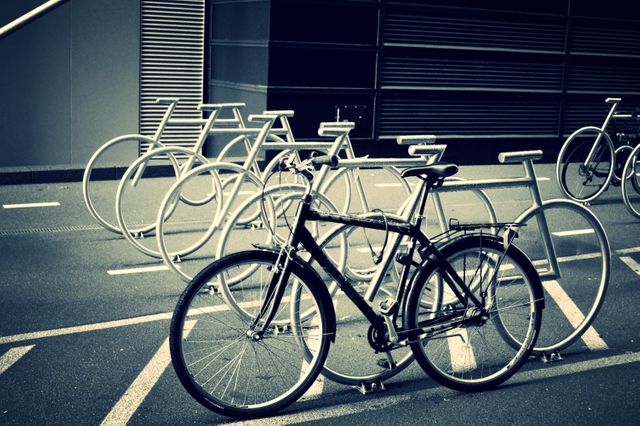 Bicycles parked in an urban area with neatly organized bike racks. Useful for illustrating city transportation, promoting cycling culture, and showcasing efficient urban design.