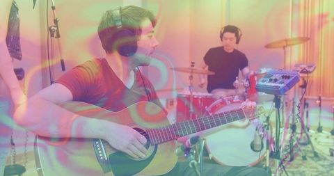 Musician recording session with acoustic guitar and drums