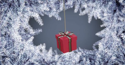 Red Gift Box Swinging Among Snow-Covered Pine Branches