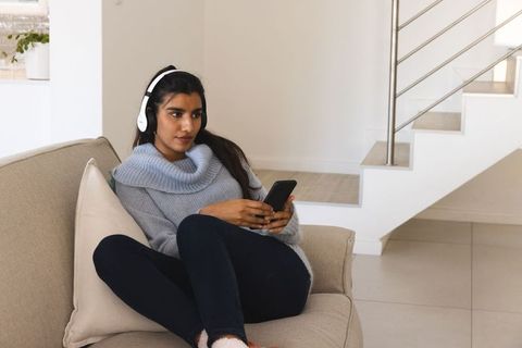 Relaxed Woman Listening to Music with Headphones at Home