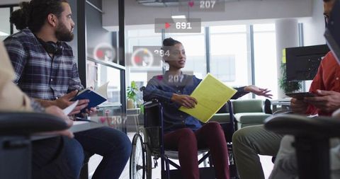 Inclusive team discussion with woman in wheelchair leading collaborative meeting in office