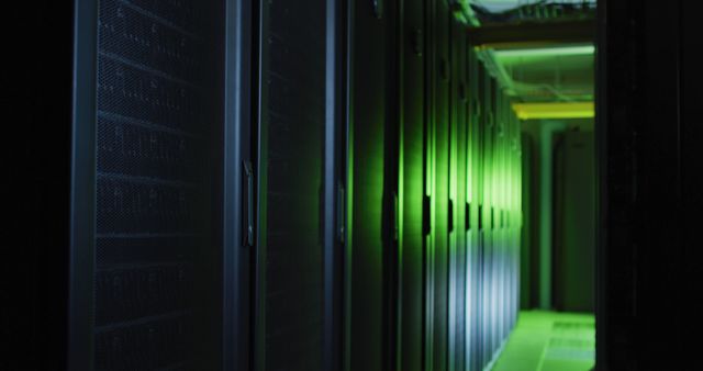 Corridor filled with rows of illuminated servers casting a green light, symbolizing high technology and digital infrastructure. Could be used for topics related to cloud computing, data security, IT infrastructure, or network management.