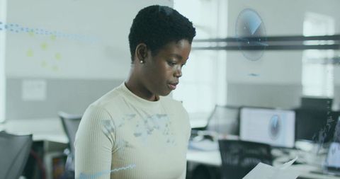 Businesswoman Reading Document in Modern Open-Plan Office