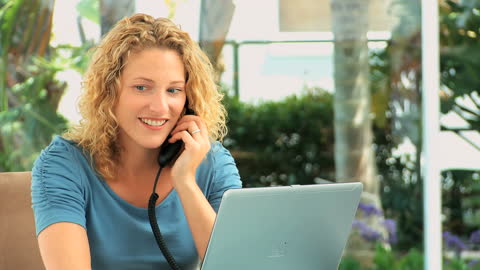 Woman Multitasking Speaking on Phone Working From Home