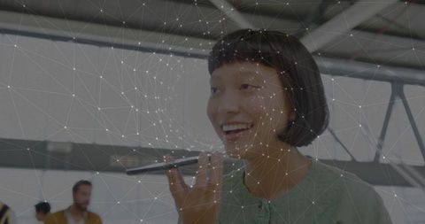 Confident professional speaking into smartphone with digital network lines