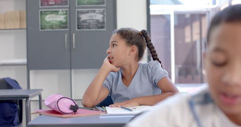 Young Girl Reflecting in Bright Classroom with Classmates - Download Free Stock Images Pikwizard.com