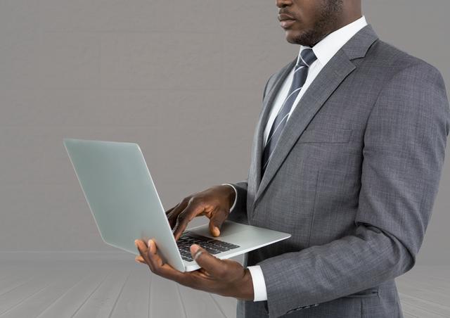 Digital composite of Business man on laptop with grey background