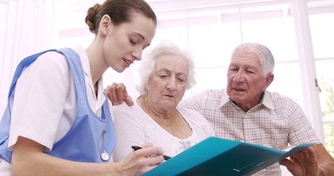 Senior Couple Discussing Health with Caring Nurse in Home
