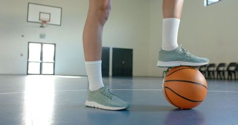 Female Athlete Balancing Basketball on Indoor Court