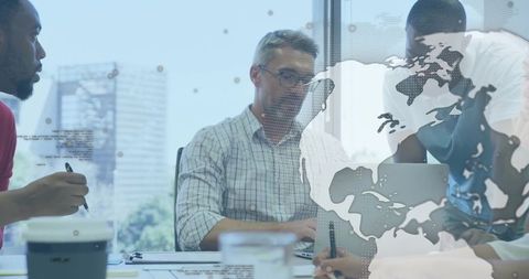 Global collaboration brainstorming with team around laptop and world map data overlay