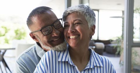 Joyful Biracial Couple Sharing a Loving Embrace in Bright Interior