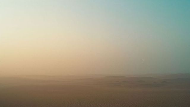 Vast and Serene Desert Dunes Under Clear Sky