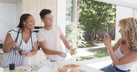 Diverse Group of Friends Cooking and Enjoying Pizza Making