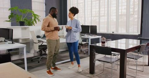 Colleagues enjoying coffee break in modern office environment