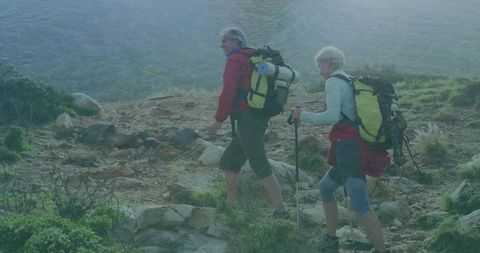 Senior couple hiking trekking through scenic lakeside trail