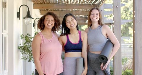 Diverse Female Friends Bonding with Yoga Mats Outdoors