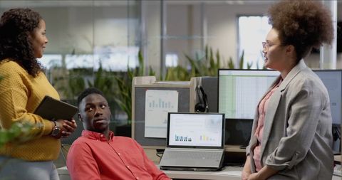 Diverse Team Discussing Digital Data in Modern Office Setting