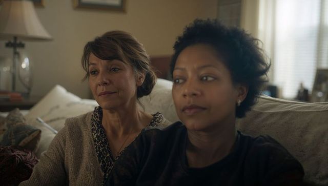 Two Women Sitting Together on Sofa Sharing Quiet Emotional Moment in Cozy Living Room