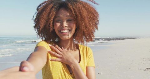 Joyful Woman Holding Partner's Hand on Sunny Beach