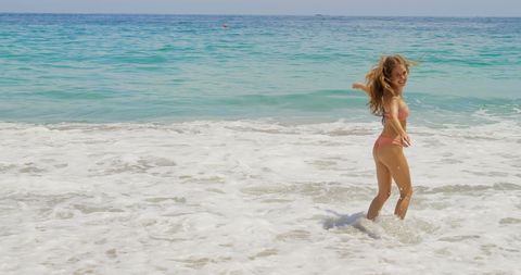 Joyful Woman Enjoying Vibrant Beach Getaway in Summer