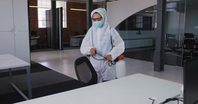 Professional Cleaner Disinfecting Office Workspace with Protective Gear - Download Free Stock Images Pikwizard.com