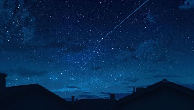 Meteor streaks across starry night sky over silhouetted rooftops