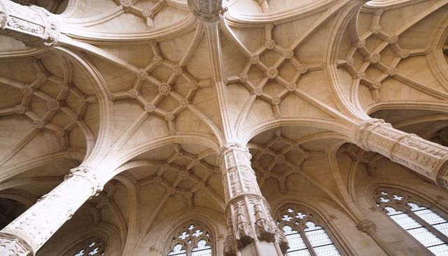 Ornate gothic ribbed vaulting with carved central column and traceried clerestory windows