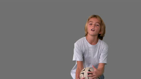 Boy Playing Rugby Catch with Focused Expression at Studio