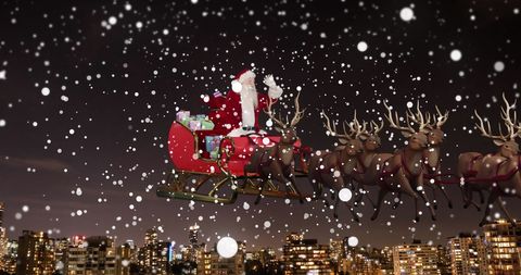Santa Claus in Sleigh with Reindeer over City at Night