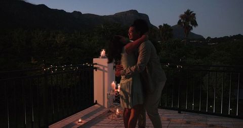 Romantic balcony proposal amid scenic nightscape