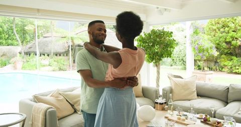 Couple dancing in living room embracing romantic moment at home