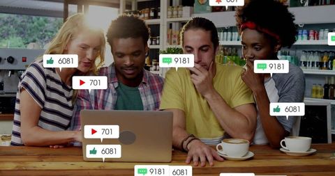 Multicultural team collaborating on laptop in cafe showing social media engagement icons