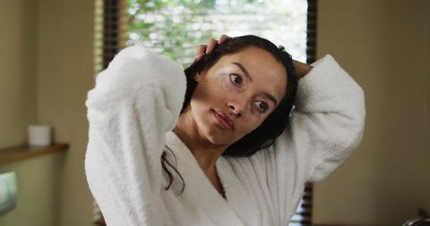 Serene Woman in Bathrobe Doing Haircare Routine at Home