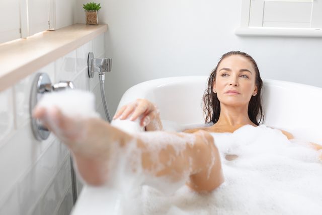Woman taking bubble bath in bathroom at home - Download Free Stock Photos Pikwizard.com