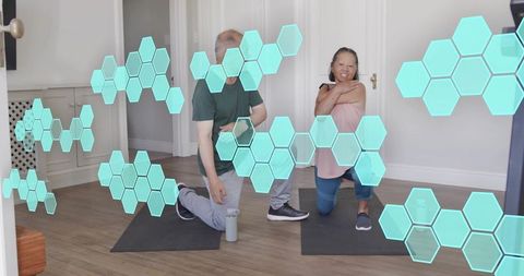 Mature couple stretching in home workout with augmented reality hexagon fitness overlay