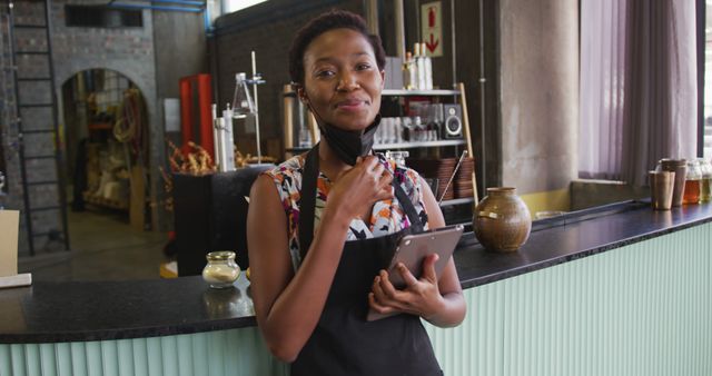 African American woman manages her bar business with a smile, tablet in hand, despite COVID-19. - Download Free Stock Photos Pikwizard.com
