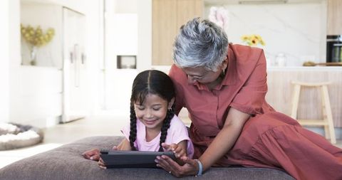 Grandmother and Granddaughter Spending Time on Digital Tablet